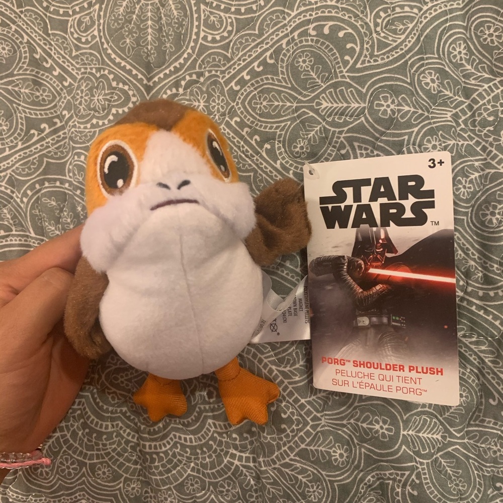 Porg sits on shoulder with magnet. Disney parks- shop Disney